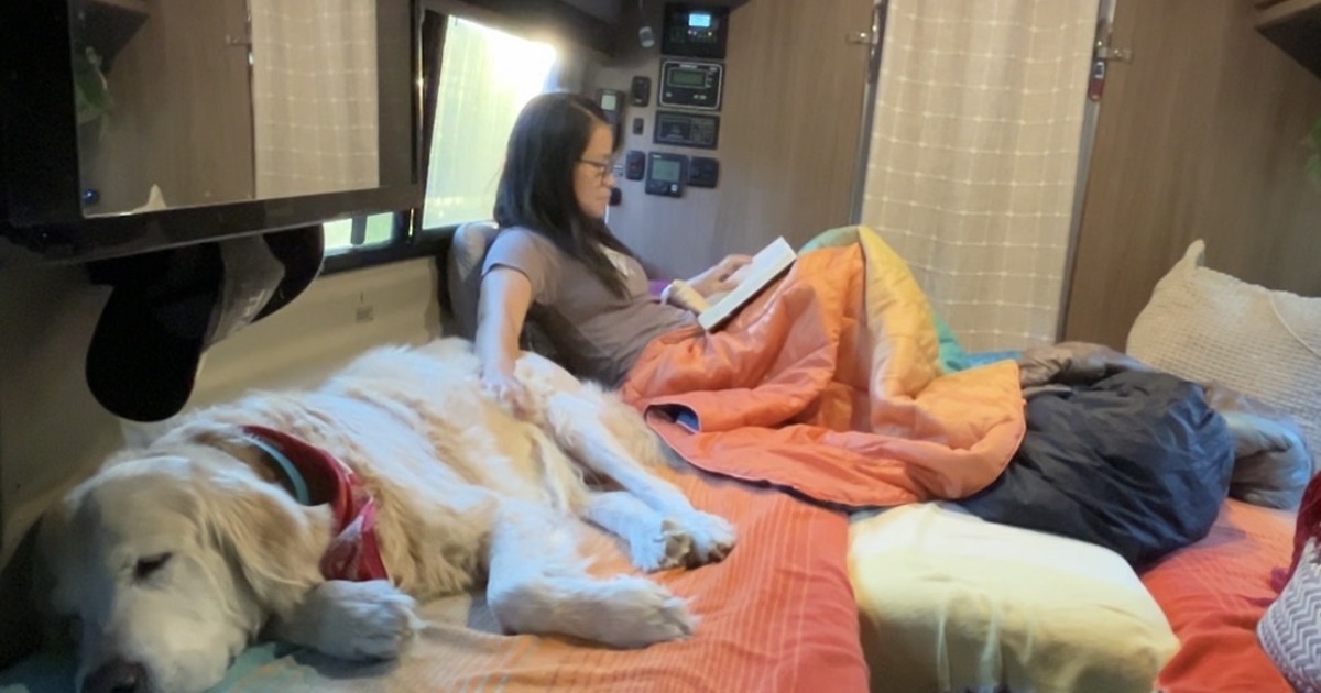 Me reading on the finished king bed in my Travato 59K with Tsali